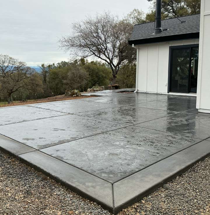 Custom slate-texture stamped concrete patio with smooth gray borders overlooking the scenic hills of El Dorado County.