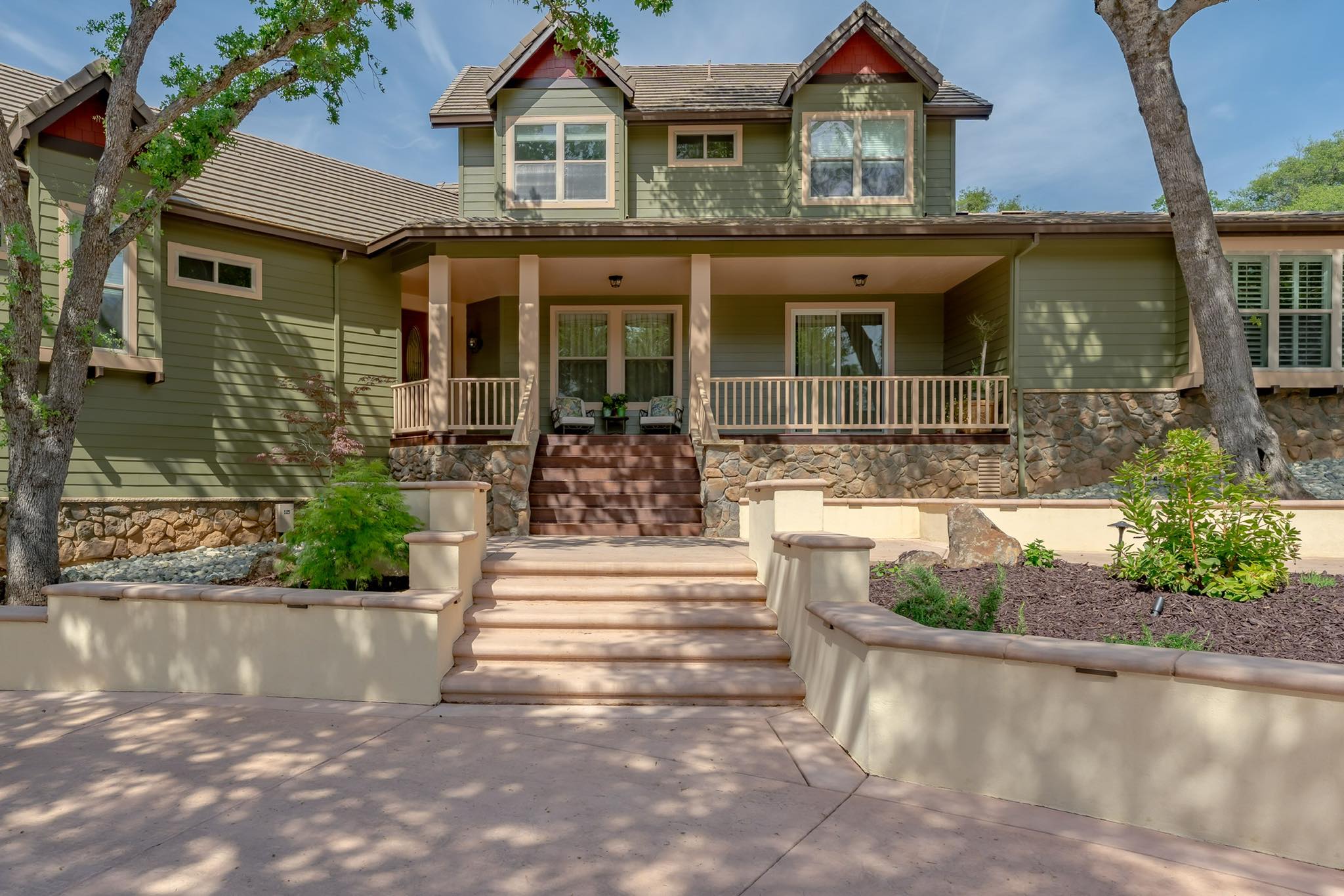 A luxury residential front yard renovation featuring a multi-level stamped concrete entryway, integrated stone planters, and clean architectural lines that enhance curb appeal.